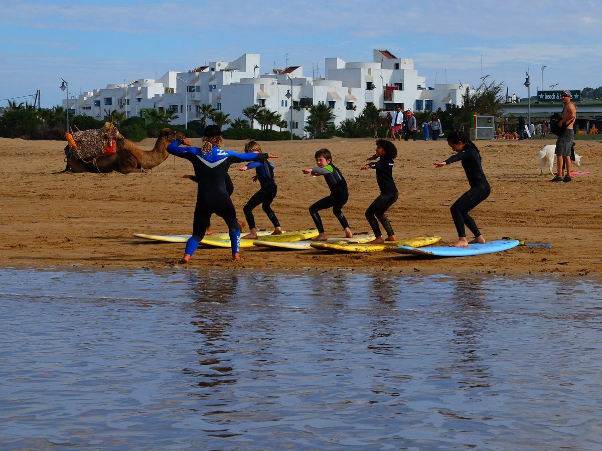 Group of surf students standing up on their boards in shallow water