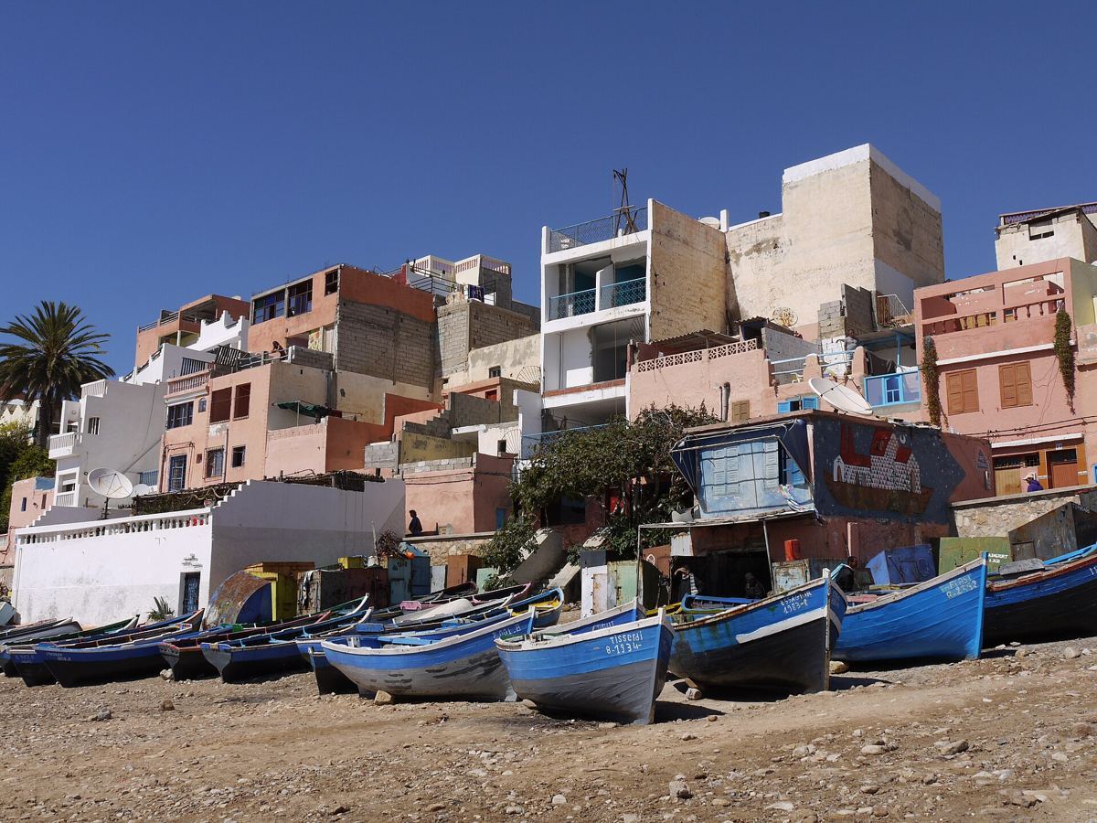 Blue fishing boats on the beach in front of Taghazout village